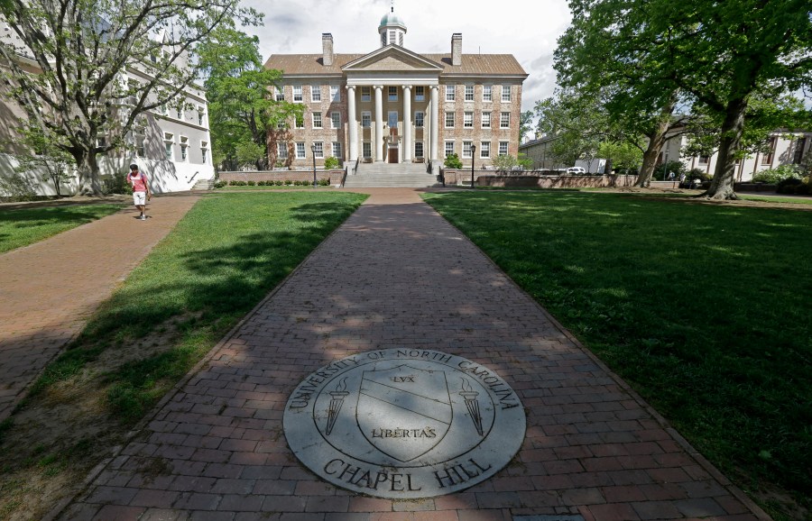 A student walks by a building on a university campus.