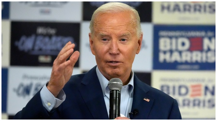 President Biden speaks in front of a wall of Biden-Harris campaign posters.