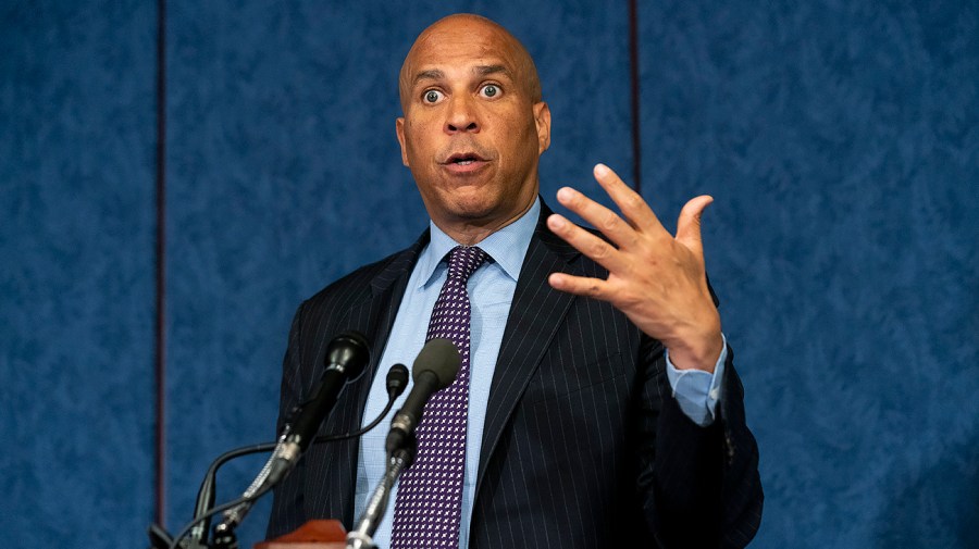 Senator Cory Booker gestures while speaking in microphone.