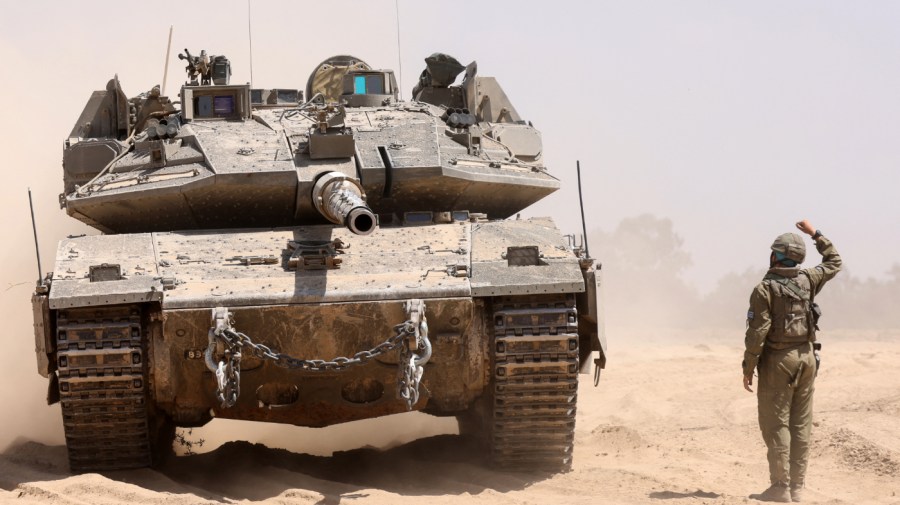 An Israeli soldier helps another to manuever a tank near the border with the Gaza Strip on May 2, 2024, amid the ongoing conflict between Israel and the Palestinian Hamas movement.