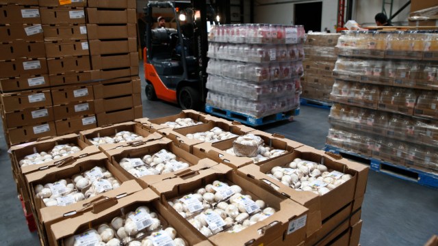 A warehouse worker unloads pallets of fresh mushrooms and other goods from trucks at the SF-Marin Food Bank in San Francisco, Calif. on Tuesday, May 23, 2017.