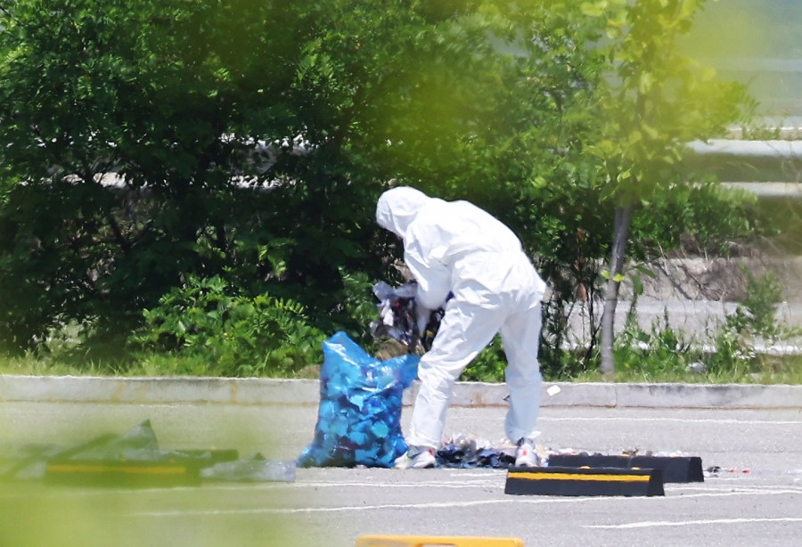 An officer wearing protective gear collects the trash from a balloon presumably sent by North Korea, in Siheung, South Korea, Sunday, June 2, 2024. South Korea said Sunday it’ll take strong retaliatory steps against North Korea over its launch of trash-carrying balloons and other provocations on South Korea. (Hong Ki-won/Yonhap via AP)