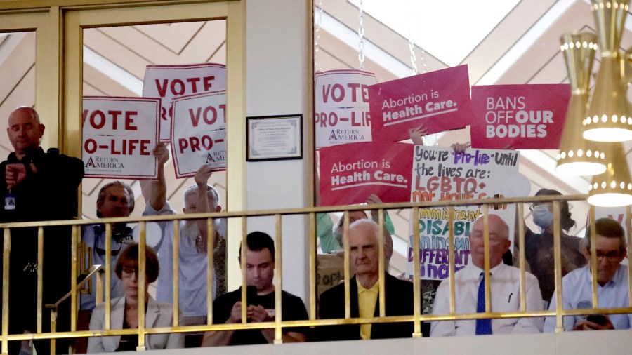 FILE - Protesters on both sides of the issue hold signs as North Carolina House members debate, May 16, 2023, in Raleigh, N.C. On Monday, June 3, 2024, a federal judge permanently blocked some efforts in North Carolina to restrict how abortion pills can be dispensed, saying they are unlawfully in conflict with the authority of the U.S. Food and Drug Administration. But she allowed other state laws to remain in effect, granting only a partial victory to a doctor who sued. (AP Photo/Chris Seward, File)