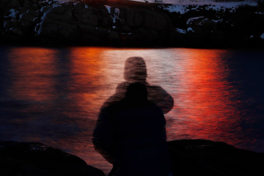 FILE - In this photo made with a long exposure, a man is silhouetted against lights reflected in the waters off Cape Neddick in Maine on Dec. 11, 2017. Federal health advisers are considering the first request to approve the mind-altering club drug MDMA as a treatment for PTSD. The advisers to the Food and Drug Administration are scheduled to vote on the drug's safety and effectiveness Tuesday, June 4, 2024, potentially setting the stage for federal approval later this year. (AP Photo/Robert F. Bukaty, File)