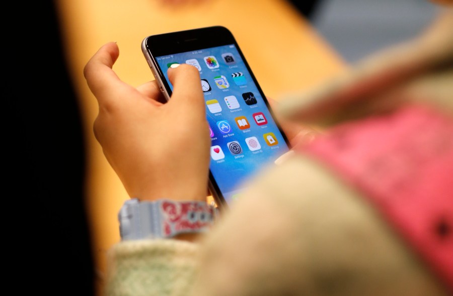 FILE - A child holds an iPhone at an Apple store on Sept. 25, 2015 in Chicago. Parents — and even some teens themselves — are growing increasingly concerned about the effects of social media use on young people. (AP Photo/Kiichiro Sato, File)