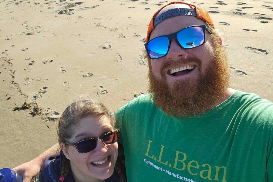 This photo provided by Patrick Acord shows him, right, with his wife, Jamie Acord, on Popham Beach, where Jamie Acord sunk to her hips in quicksand, Saturday, June 1, 2024, in Phippsburg, Maine. (Patrick Acord via AP)