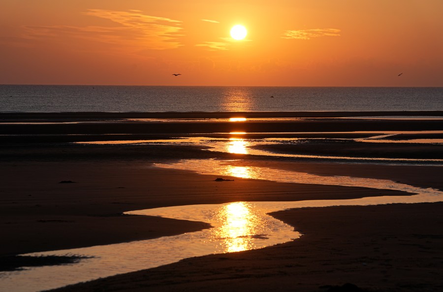 Sun rises over Omaha Beach near Colleville-sur-Mer Normandy, Thursday, June 6, 2024. World War II veterans from across the United States as well as Britain and Canada are in Normandy this week to mark 80 years since the D-Day landings that helped lead to Hitler's defeat. (AP Photo/Laurent Cipriani)