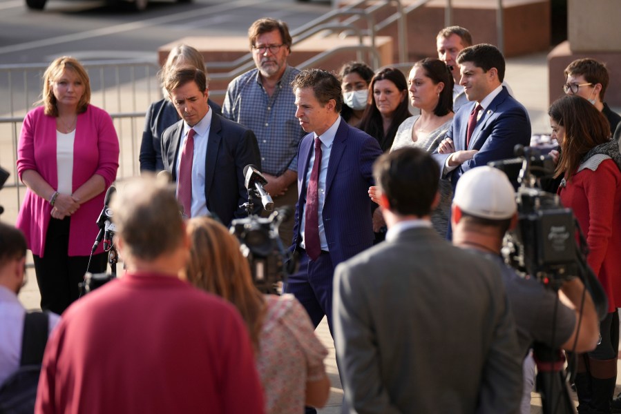 FILE - The lawyers representing the families of the victims of the shooting at Sandy Hook Elementary speak to the media after jurors returned a $965 million dollar judgement in the defamation trial against Alex Jones, in Waterbury, Conn, Oct. 12, 2022. Jones asked the court Wednesday, June 5, 2024, for permission to convert his personal bankruptcy reorganization to a liquidation, which would lead to a sell-off of a large portion of his assets to help pay some of the $1.5 billion he owes relatives of victims of the shooting. (AP Photo/Bryan Woolston, File)