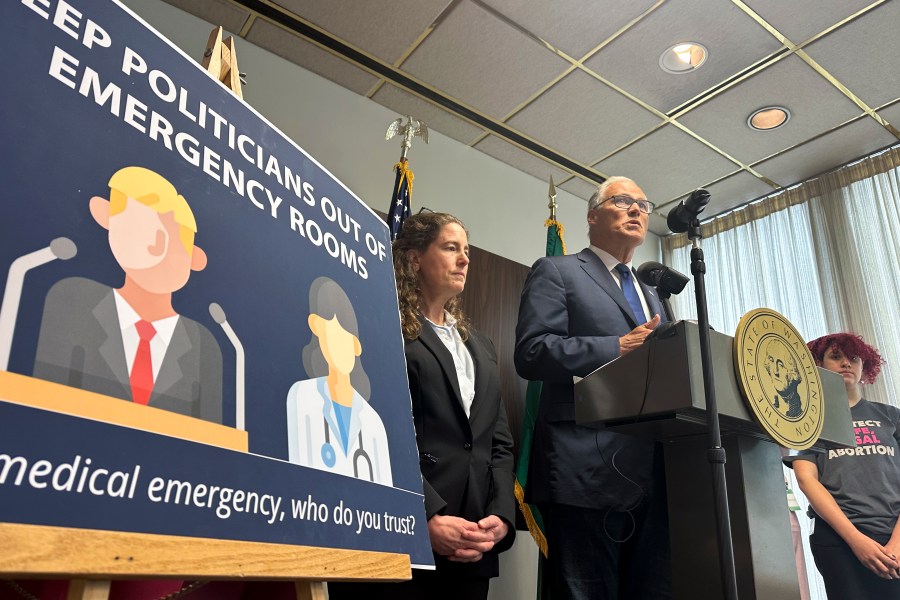 Washington Gov. Jay Inslee speaks to reporters during a news conference in Seattle, Tuesday, June 11, 2024, as abortion rights supporters listen. Inslee announced that Washington state will spell out in state law that hospitals must provide abortions if needed to stabilize patients, a step that comes as the U.S. Supreme Court is expected to rule this month on whether conservative states can bar abortions during some medical emergencies. (AP Photo/Gene Johnson)