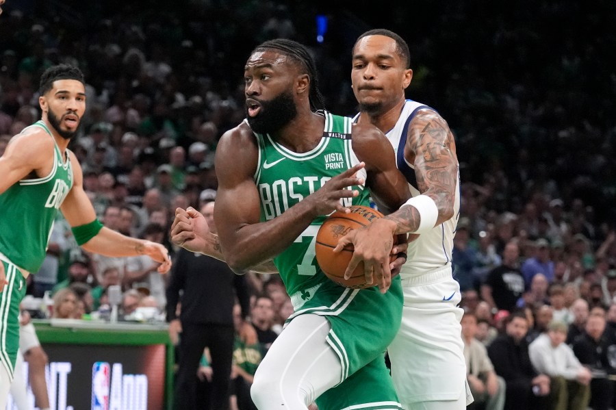 Boston Celtics guard Jaylen Brown, center, drives toward the basket as Dallas Mavericks forward P.J. Washington, right, defends and Celtics forward Jayson Tatum, left, watches during the first half of Game 5 of the NBA basketball finals, Monday, June 17, 2024, in Boston. (AP Photo/Charles Krupa)