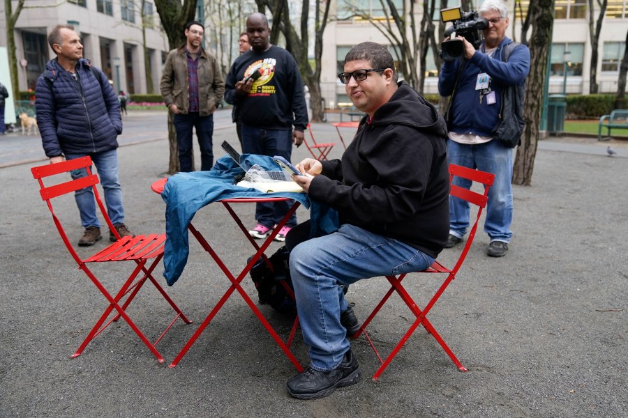 FILE - Jason Anthony, an Amazon worker and union organizer, keeps track of the ongoing count of votes to unionize an Amazon warehouse outside an office of the National Labor Relations Board in New York, on May 2, 2022. Amazon's union workers are aligning themselves with the Teamsters, overwhelmingly voting in favor of an affiliation. The union members voted 98.3% in favor of the affiliation, the International Brotherhood of Teamsters said Tuesday, June 18, 2024. (AP Photo/Seth Wenig)