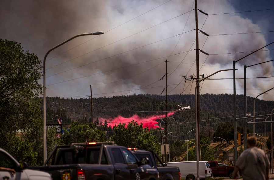 An air tanker drops fire retardant called slurry over and around wildfire-affected areas in the village of Ruidoso, N.M., Tuesday, June 18, 2024. (Chancey Bush/The Albuquerque Journal via AP)