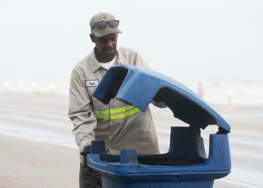 Galveston city worker Sean Kirby checks trash cans along Seawall Boulevard as rain falls Wednesday, June 19, 2024, in Galveston, Texas. Tropical Storm Alberto has formed in the southwestern Gulf of Mexico, the first named storm of what is forecast to be a busy hurricane season. (Jason Fochtman/Houston Chronicle via AP)