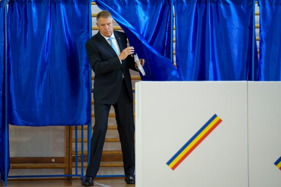 Romanian President Klaus Iohannis exits a voting cabin during European and local elections in Bucharest, Romania, Sunday, June 9, 2024. Voters across the European Union are going to the polls on the final day of voting for the European parliamentary elections to choose their representatives for the next five-year term. (AP Photo/Andreea Alexandru)