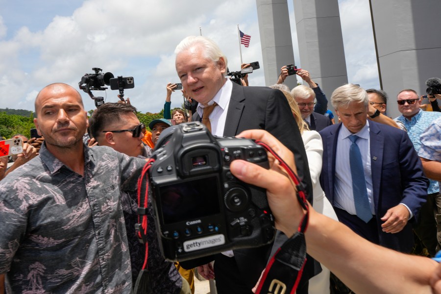 WikiLeaks founder Julian Assange, centre, is escorted to a vehicle as he leaves the federal court in Saipan, Mariana Islands, Wednesday, June 26 2024. (AP Photo/Eugene Hoshiko)