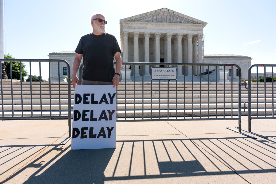 Activist Bill Christeson protests in front of the Supreme Court as decisions are announced, on Capitol Hill in Washington, Friday, June 21, 2024. The justices are still weighing whether former President Donald Trump is immune from criminal prosecution in the election interference case against him, roughly two months after hearing arguments. (AP Photo/J. Scott Applewhite)