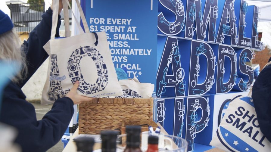 People hold up bags at a "Shop Small" event.