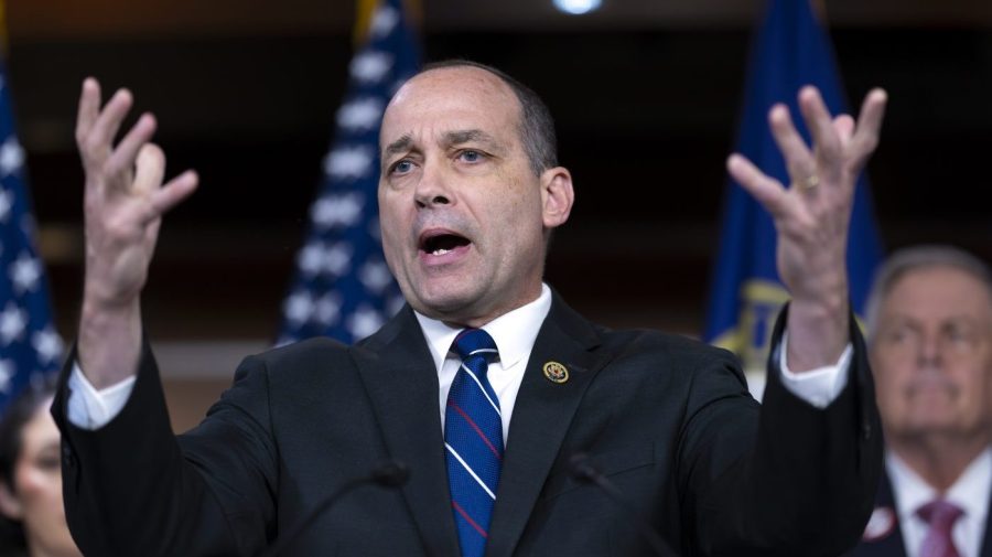 Representative Bob Good holds his hands up at a press conference.