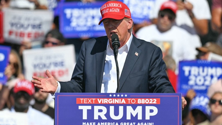 President Trump wears his iconic red MAGA hat while speaking at a campaign rally.