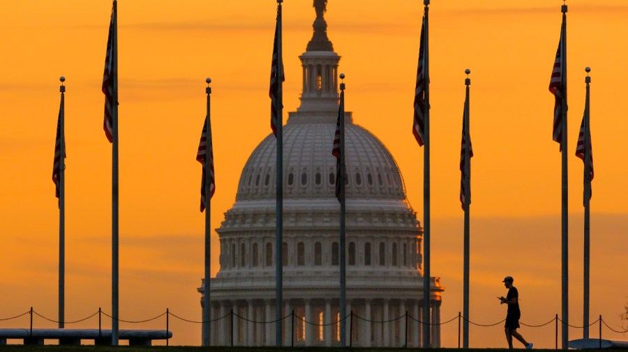 The U.S. Capitol Building looms behind flags on the National Mall in Washington Nov. 7, 2022. Fitch Ratings has downgraded the United States government's credit rating, citing rising debt at the federal, state, and local levels and a "steady deterioration in standards of governance" over the past two decades.(AP Photo/J. David Ake, File)