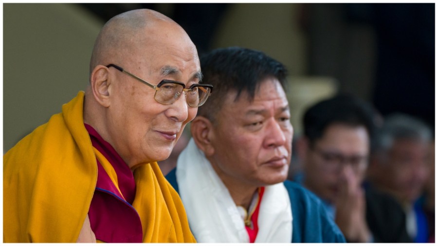 Tibetan spiritual leader the Dalai Lama smiles as he sits next to Penpa Tsering, the president of the Central Tibetan Administration.