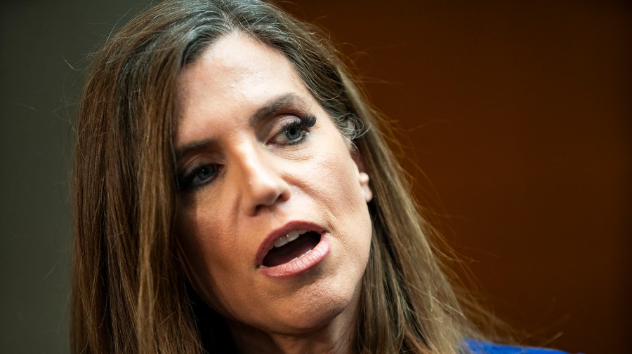 Representative Nancy Mace tilts her head to the side while speaking to reporters.