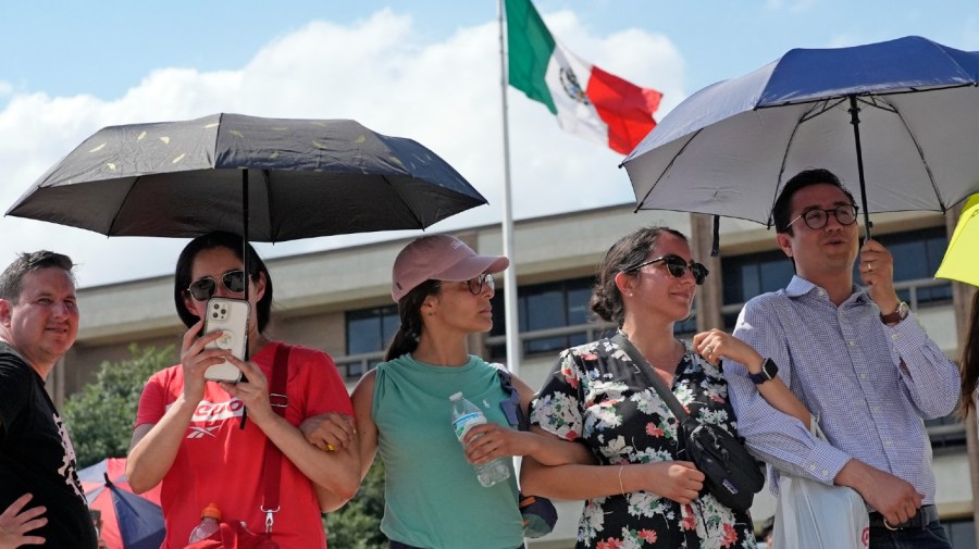 People join arms to prevent others from cutting in line as they wait to vote in the Mexican election at the Mexican Consulate building Sunday, June 2, 2024, in Houston. Houston and Dallas were the only two consulate locations in Texas where Mexican nationals could go to vote. Mexicans went to the polls Sunday to vote for who will likely be the country's first female president. (AP Photo/David J. Phillip)