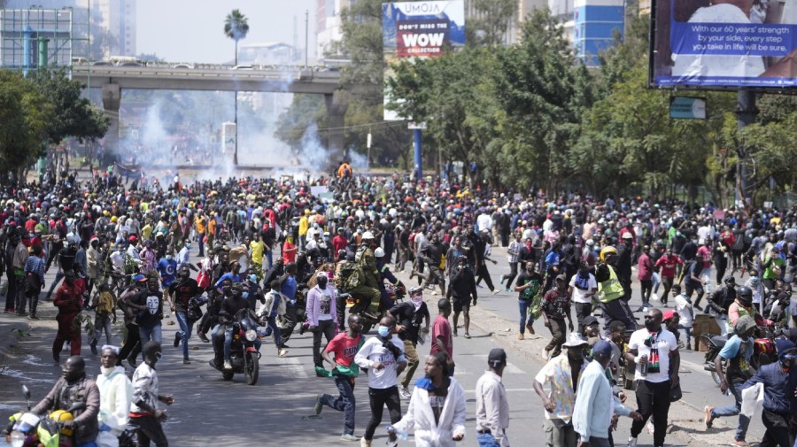 Protesters scatter as Kenya police spray water canon at them during a protest over proposed tax hikes in a finance bill in downtown Nairobi, Kenya Tuesday, June. 25, 2024.