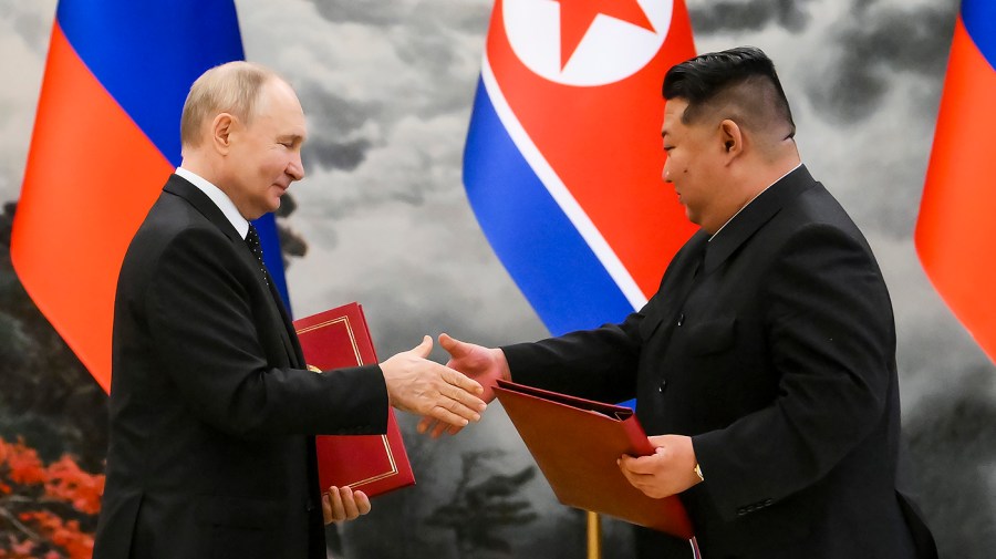 Russian President Vladimir Putin, left, and North Korea's leader Kim Jong Un exchange documents