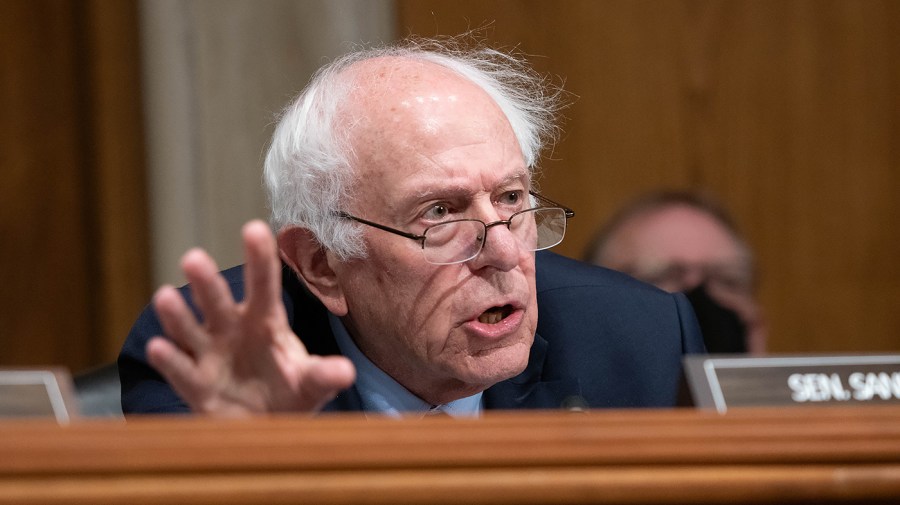 Senator Bernie Sanders gestures while giving remarks at a congressional hearing.