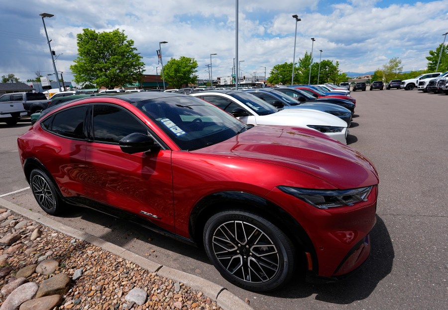 FILE - A line of unsold 2024 Mustang Mach-E electric utility vehicles sit at a Ford dealership May 19, 2024, in Denver. On Tuesday, July 2, 2024, automakers will report second-quarter U.S. sales and they're expected to be flat compared with a year ago. (AP Photo/David Zalubowski, File)