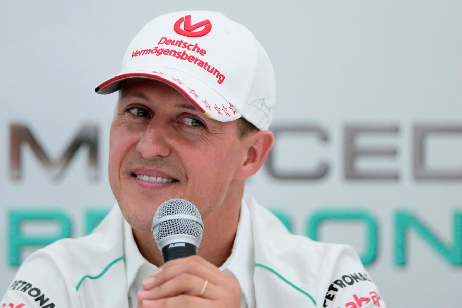 FILE - Michael Schumacher announces his retirement from Formula One during a press conference at the Suzuka Circuit venue for the Japanese Formula One Grand Prix in Suzuka, Japan, Oct. 4, 2012. German prosecutors say two men who allegedly tried blackmailing the family of former Formula 1 champion Michael Schumacher were detained earlier this month. Prosecutors in the western German city of Wuppertal said Monday the suspects told employees of the family that they were in possession of files that the family would not want to be published. (AP Photo/Itsuo Inouye, file)