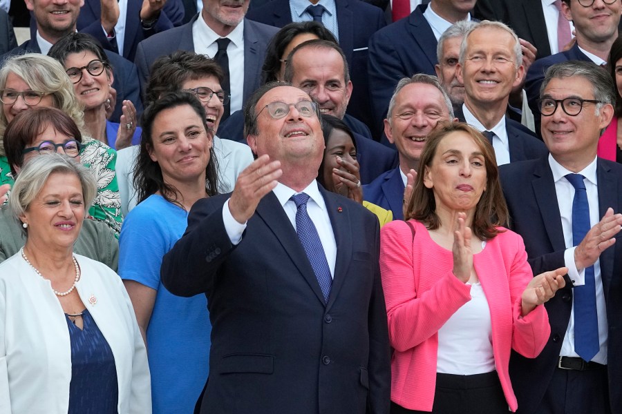 Newly elected parliament members of the Socialist party, with former French President Francois Hollande at center, pose at the National Assembly, Tuesday, July 9, 2024 in Paris. French voters have given a broad leftist coalition the most parliamentary seats in a pivotal legislative election that has kept the far right from power but has put France in the unprecedented position of having no dominant political bloc in parliament. (AP Photo/Michel Euler)