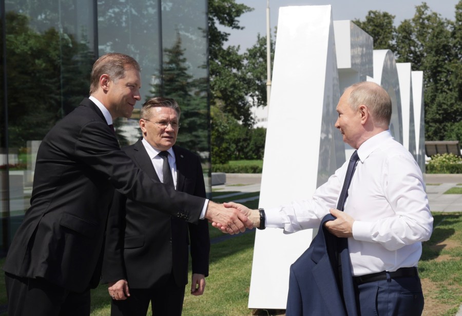 Russian First Deputy Prime Minister Denis Manturov, left, Russian State Atomic Energy Corporation Rosatom CEO Alexey Likhachev, center, greet Russian President Vladimir Putin at the Atom pavilion at Exhibition of Achievements of National Economy (VDNKh) in Moscow, Russia, Tuesday, July 9, 2024. (Gavriil Grigorov, Sputnik, Kremlin Pool Photo via AP)