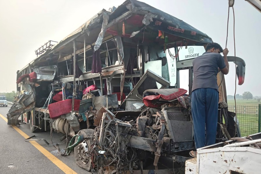 A roadside assistance worker tows away the mangled remains of a double-decker passenger bus that collided with a milk truck, near Unnao, in northern India state of Uttar Pradesh, Wednesday, July 10, 2024. Officials said the collision killed and injured multiple people. (AP Photo)