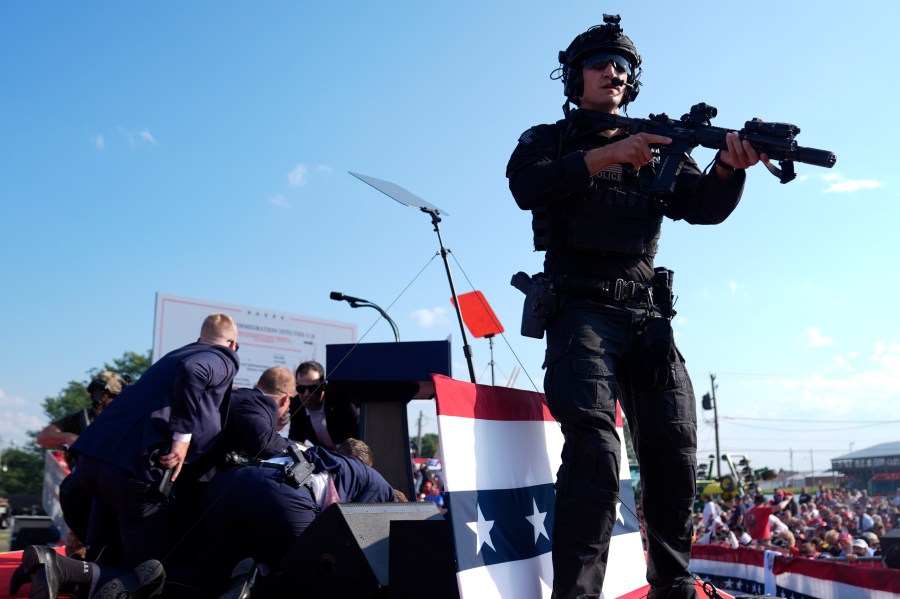 Republican presidential candidate former President Donald Trump is covered by U.S. Secret Service agents at a campaign rally, Saturday, July 13, 2024, in Butler, Pa. (AP Photo/Evan Vucci)