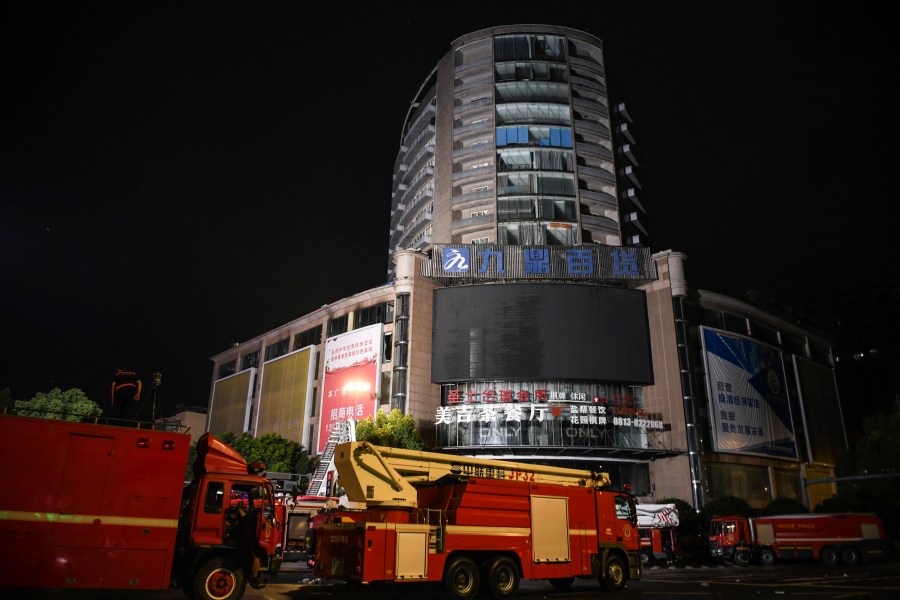 In this photo released by Xinhua News Agency, fire engines are parked near a department store in Zigong City, southwest China's Sichuan Province on Thursday, July 18, 2024, following Wednesday's deadly fire at the department store. (Wang Xi/Xinhua via AP)