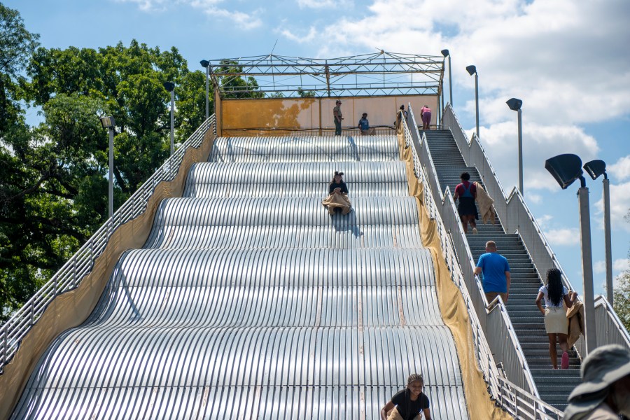 People ride the newly reopened Giant Slide at Belle Isle in Detroit on Friday, July 19, 2024. (Neo Hopkins/Detroit News via AP)