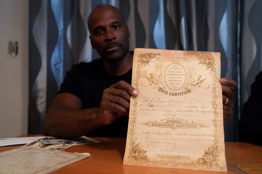 Matthew Burgess holds up the birth certificate for his grandfather, Rufus Morgan Burgess Jr., at his home Monday, Oct. 9, 2023, in Sacramento, Calif. (AP Photo/Godofredo A. Vásquez)