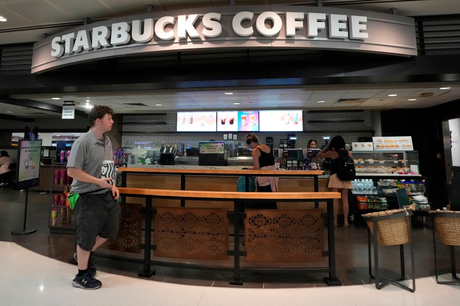 A patron walks out of a Starbucks at Phoenix Sky Harbor International Airport Friday, July 19, 2024, in Phoenix. A global technology outage grounded flights, knocked banks offline and media outlets off air after a faulty software update disrupted companies and services around the world and highlighted their dependence on just a handful of providers (AP Photo/Ross D. Franklin)