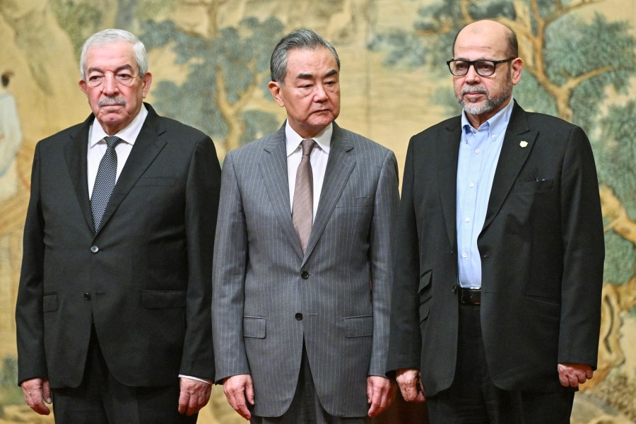 China's Foreign Minister Wang Yi, center, hosts an event for Mahmoud al-Aloul, left, vice chairman of Fatah, and Mussa Abu Marzuk, a senior member of Hamas, to meet at the Diaoyutai State Guesthouse in Beijing, Tuesday, July 23, 2024. (Pedro Pardo/Pool Photo via AP)