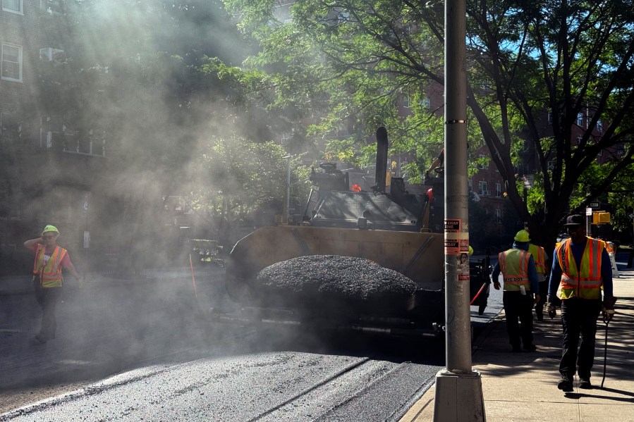 A road crew repaves a road in the Forest Hills neighborhood in the Queens borough of New York, Monday, July 1, 2024. As areas across the U.S. continue to experience extreme heat, employers have taken steps to protect workers from high temperatures. (AP Photo/Daniel P. Derella)