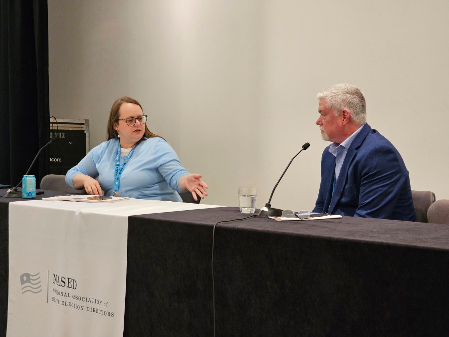 Molly Woon, left, elections director with the Oregon Secretary of State's Office, leads a panel discussion on mail voting on Tuesday, July 23, 2024, in Minneapolis, at the summer conference of the National Association of State Election Directors. She's speaking with Steven Carter, manager of election and government programs for the U.S. Postal Service. State election directors from across the country expressed serious concerns to him that mail system won't be able to handle an expected crush of mail-in ballots in the November election. (AP Photo/Steve Karnowski)