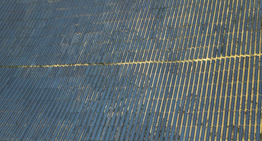 FILE - Solar panels work in Quy Non, Vietnam, June 11, 2023. (AP Photo/Minh Hoang, File)