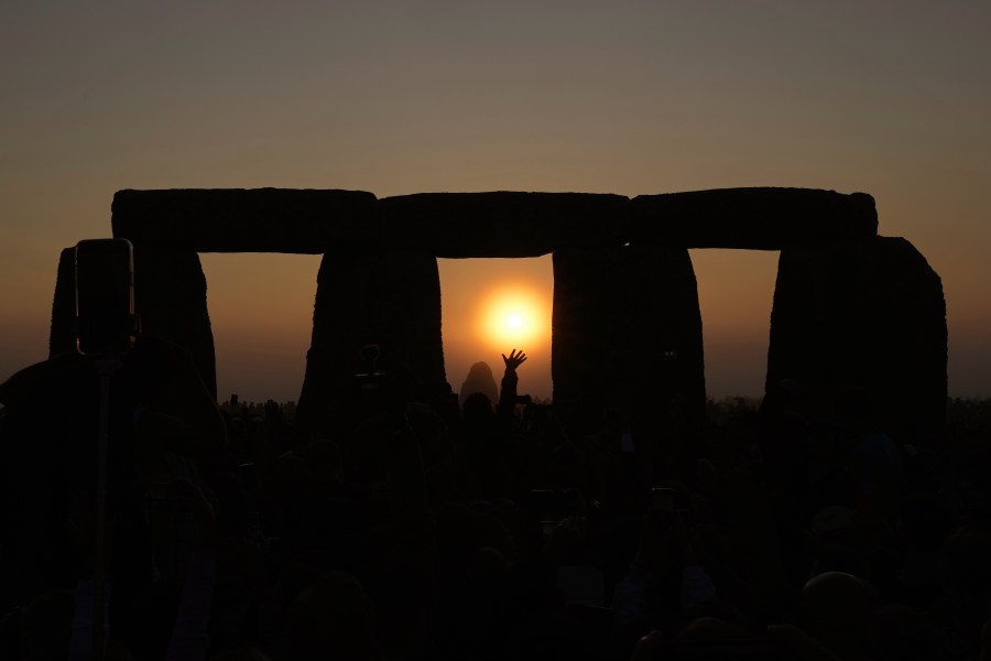 FILE - Revelers gather at the ancient stone circle Stonehenge to celebrate the Summer Solstice, the longest day of the year, near Salisbury, England, Wednesday, June 21, 2023. The United Nations’ cultural agency has rejected recommendations to place Stonehenge on the list of world heritage sites in danger over concerns that Britain’s plans to build a nearby highway tunnel threaten the landscape around the prehistoric monument. (AP Photo/Kin Cheung, File)