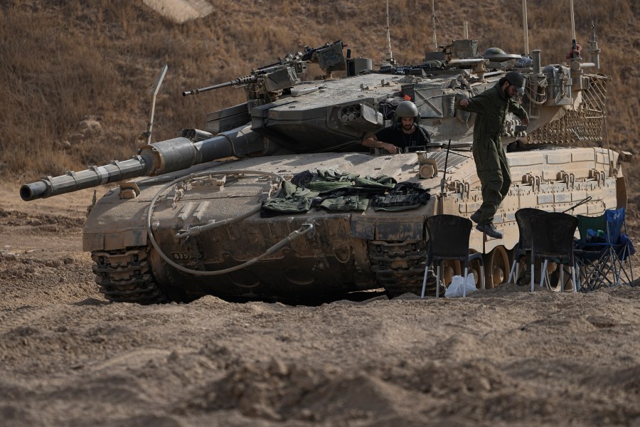 An Israeli soldier jumps from the top of a tank in an area near the Israeli-Gaza border, seen from southern Israel, Wednesday, July 24, 2024. (AP Photo/Tsafrir Abayov)