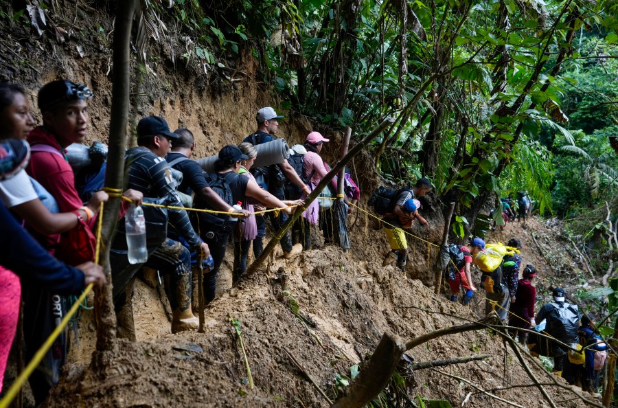 FILE - Migrants, mostly Venezuelans, walk across the Darien Gap from Colombia into Panama, hoping to reach the U.S., Oct. 15, 2022. Refugee agency UNHCR estimates more than 7.7 million Venezuelans have left since 2014, the largest exodus in Latin America’s recent history, with most settling in the Americas, from neighboring Colombia and Brazil to Argentina and Canada. (AP Photo/Fernando Vergara, File)