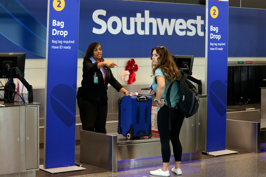 A passenger checks in for her Southwest Airlines flight at Midway International Airport in Chicago, Thursday, July 25, 2024. Southwest Airlines plans to drop the open-boarding system it has used for more than 50 years and will start assigning passengers to seats, just like all the other big airlines. (AP Photo/Teresa Crawford)