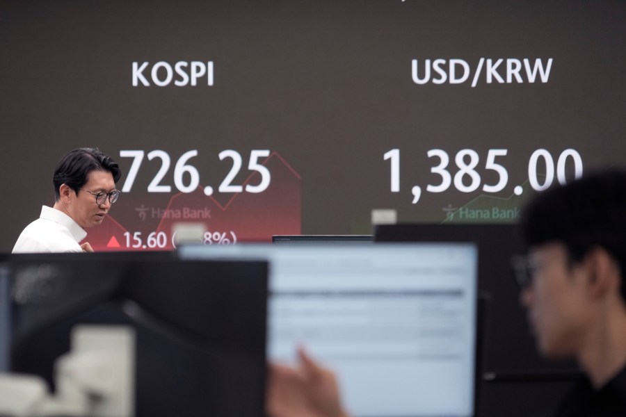 Currency traders watch monitors near the screen showing the Korea Composite Stock Price Index (KOSPI), left, and the foreign exchange rate between U.S. dollar and South Korean won at the foreign exchange dealing room of the KEB Hana Bank headquarters in Seoul, South Korea, Friday, July 26, 2024. (AP Photo/Ahn Young-joon)