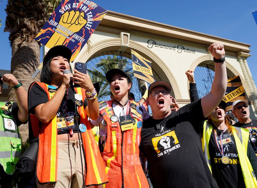 FILE - SAG-AFTRA captains Iris Liu, left, and Miki Yamashita, center, and SAG-AFTRA chief negotiator Duncan Crabtree-Ireland lead a cheer for striking actors outside Paramount Pictures studio, Nov. 3, 2023, in Los Angeles. Hollywood's video game performers voted to go on strike Thursday, July 25, 2024, throwing part of the entertainment industry into another work stoppage after talks for a new contract with major game studios broke down over artificial intelligence protections. (AP Photo/Chris Pizzello, File)